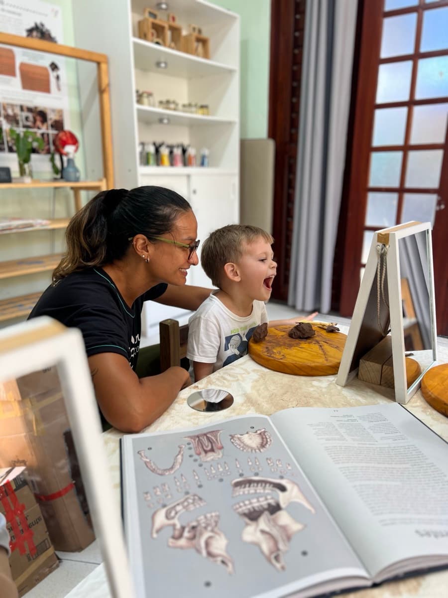 Educadora e criança descobrindo um livro de arte