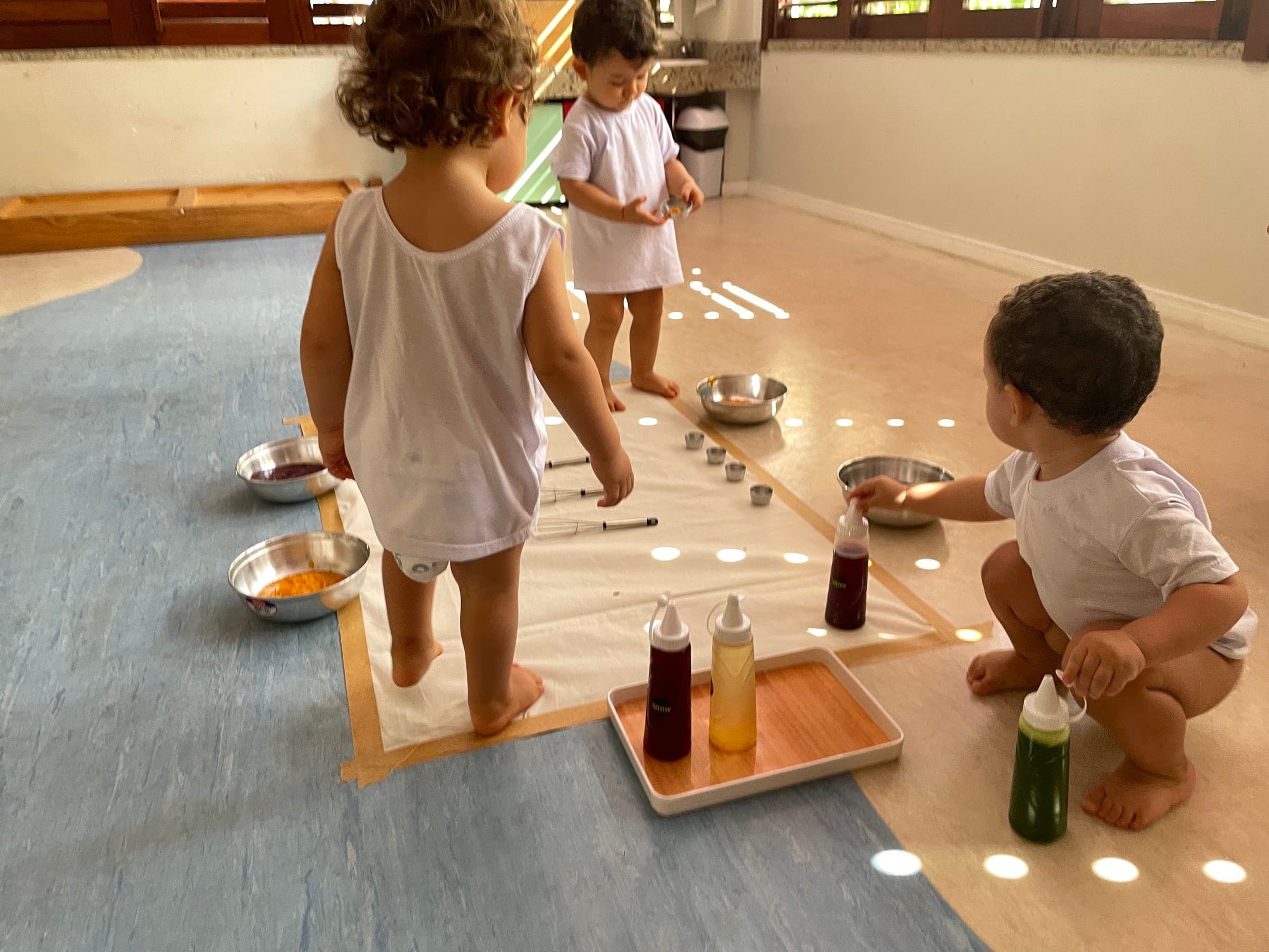 Bebês em vivência sensorial com tintas no Ateliê Aquarela